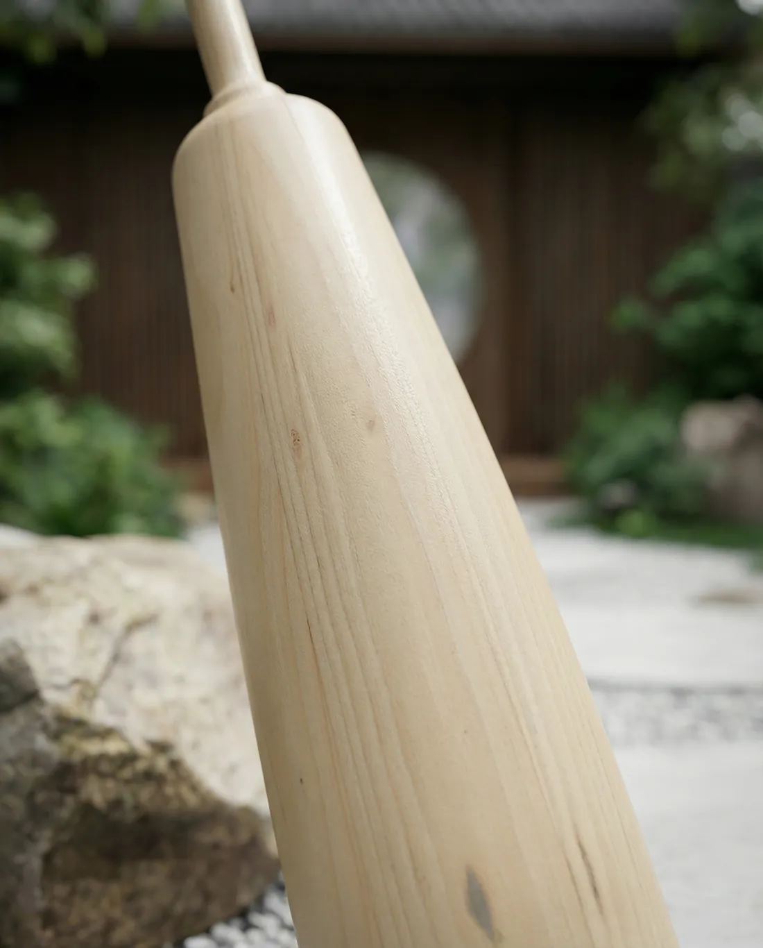 Cuerpo de una maza de madera clara en diagonal, con la veta fina visible